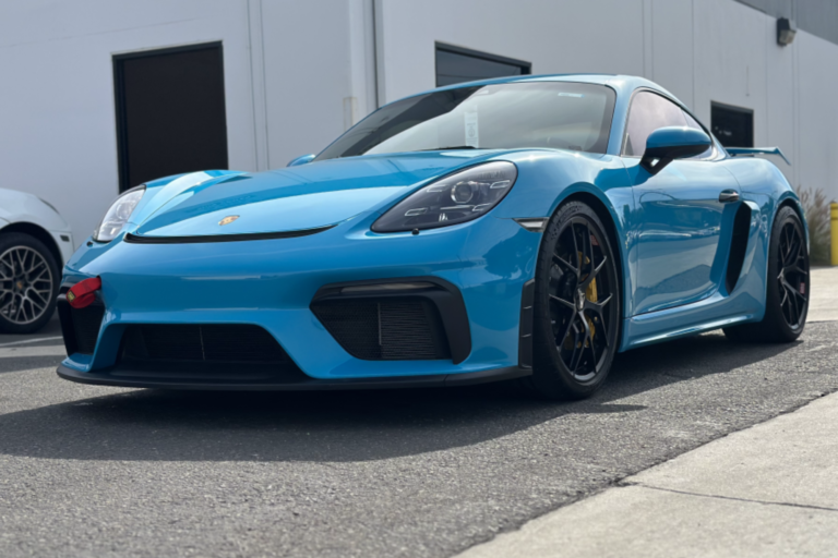 a blue sports car parked in front of a building